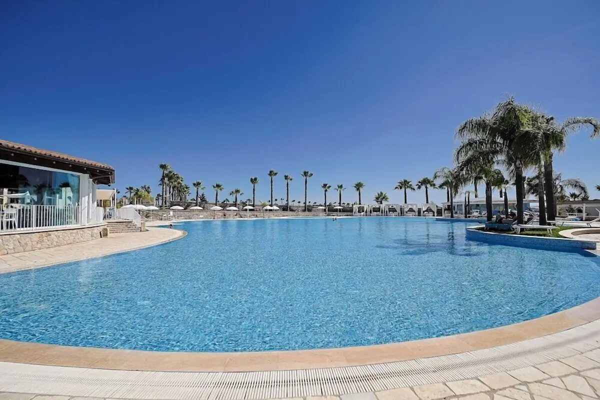 Expansive swimming pool surrounded by palms