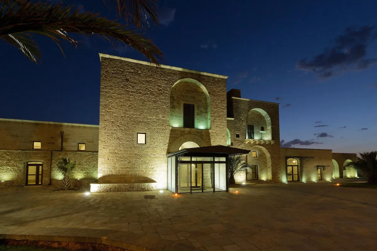 Historic limestone facade of Resort Masseria Ristoppia at night